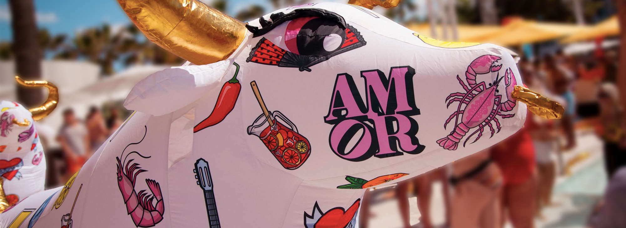 Image of inflatable bull with Spanish emojis on it such as a chilli, the word 'amor', sangria, a lobster and a Spanish guitar