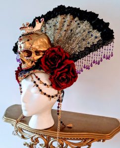 Large headdress with a gold skull, red flowers, lace fan and jewels 